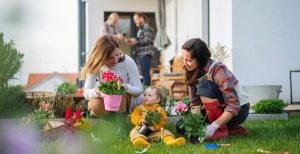 A happy multigeneration family planting flowers in their garden