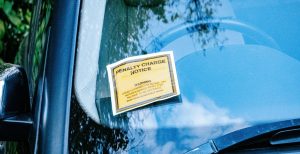 A car with a parking ticket on its windshield