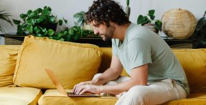 Man sitting on sofa and using his laptop