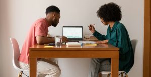 Couple sitting at table working something out on a laptop