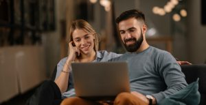 A young couple looking at their laptop while on a mortgage appointment