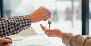Two people exchanging keys at a table