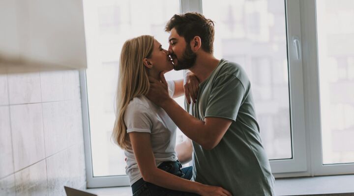 A young first time home buyer couple kissing