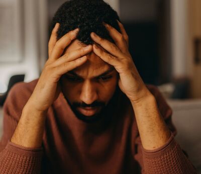 A man with his head in his hands looking frustrated