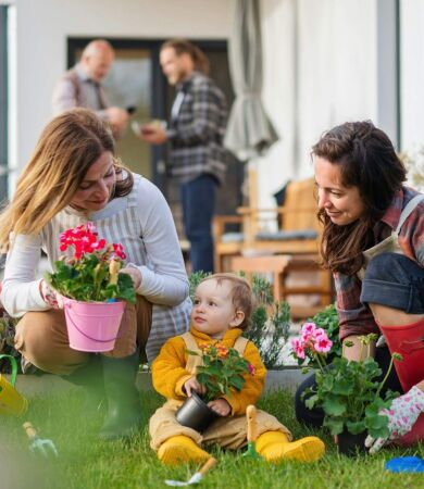A happy multigeneration family planting flowers in their garden