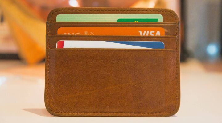 Three credit cards in a brown leather wallet