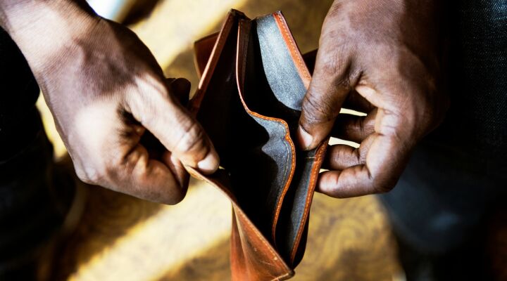 A person opening an empty wallet