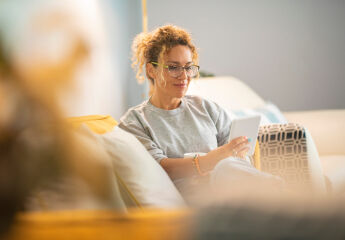 A woman sitting on the sofa looking at her iPad