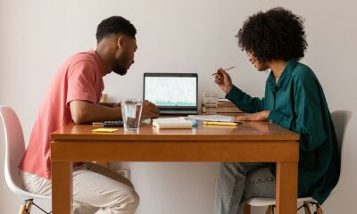 Couple sitting at table working something out on a laptop