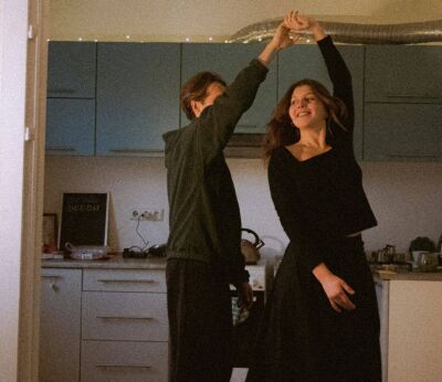 Two first-time buyers dancing in the kitchen after buying their first house with the help of a mortgage broker