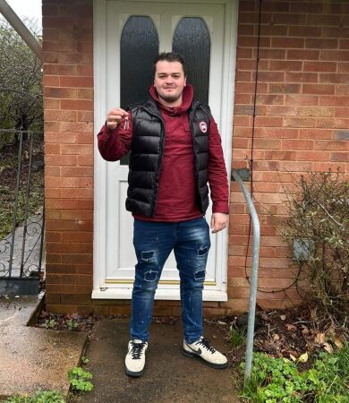 Jack Tucker - First-Time Buyer client of The Levels Financial standing outside of his new house while holding up the keys