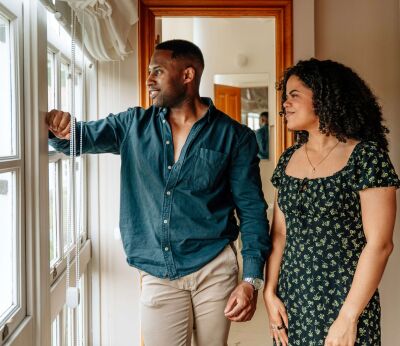 A couple looking out of the window while on a house viewing