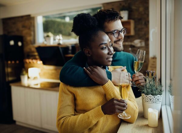 A young couple drinking champagne in their kitchen after moving into their new home