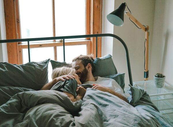 A young couple laying in bed together
