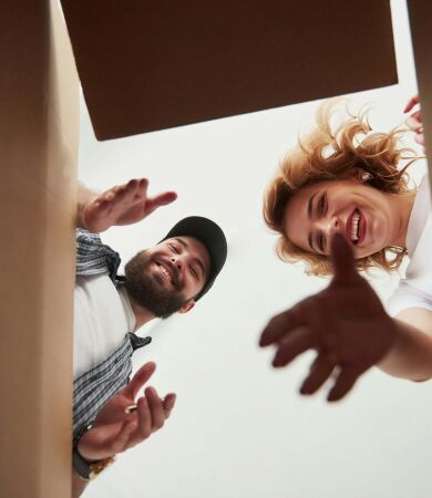 A young couple reaching into a box while moving home