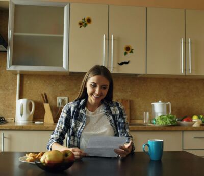 A woman looking over her documents for remortgaging while sitting in her kitchen