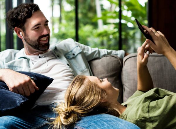 Couple sitting on the sofa looking at a phone