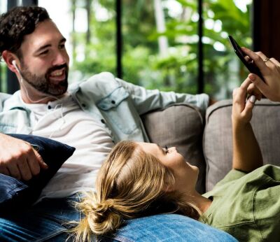 Couple sitting on the sofa looking at a phone