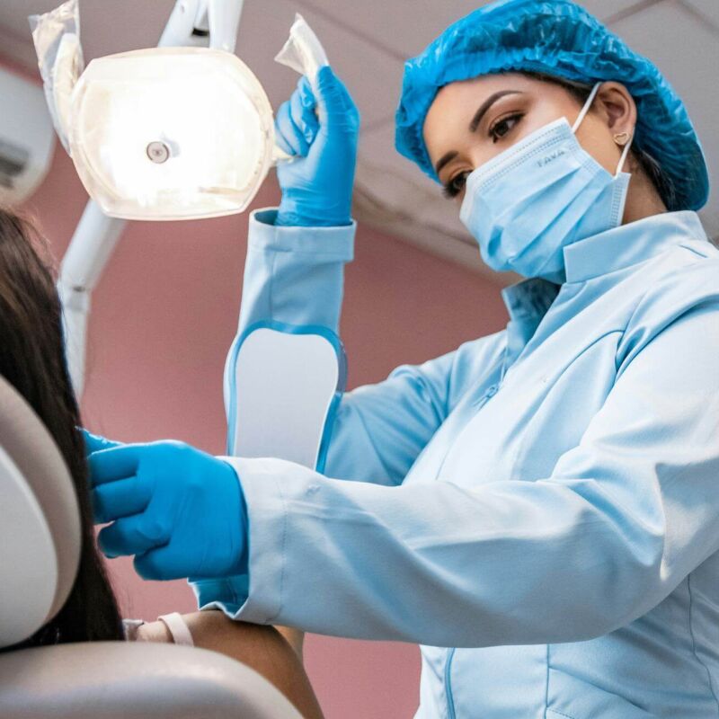 A dentist shining a light into a patients mouth to look at their teeth
