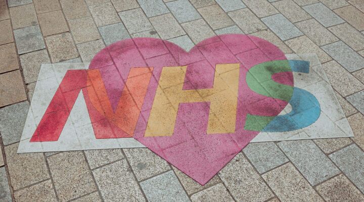 NHS and heart art illustration painted on a brick floor