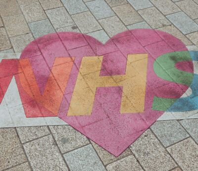 NHS and heart art illustration painted on a brick floor